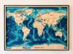 World map wall art in layered blue wood with engraved country names and black frame